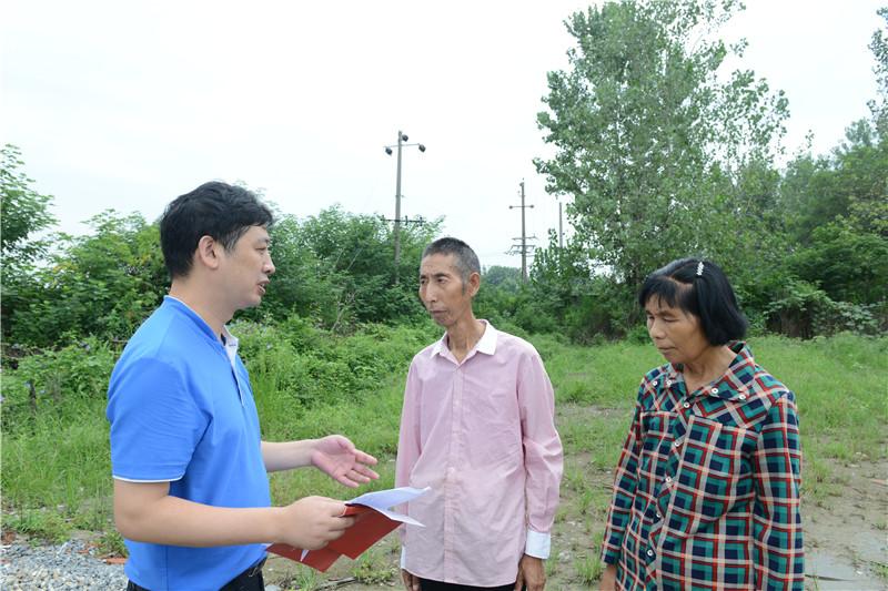 市二医财务科科长朱俊柏在田间地头向其包保对象——吕集村5组村民吕义美两夫妻宣讲农村低保和医疗救助等方面的政策。.jpg